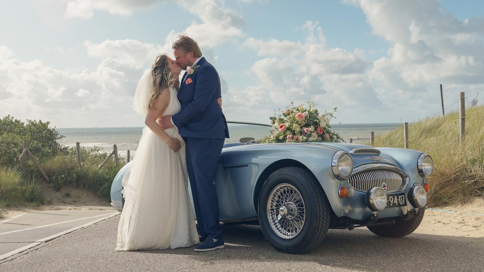 Bruidspaar bij trouwauto, vastgelegd in een stijlvolle en professionele trouwvideo