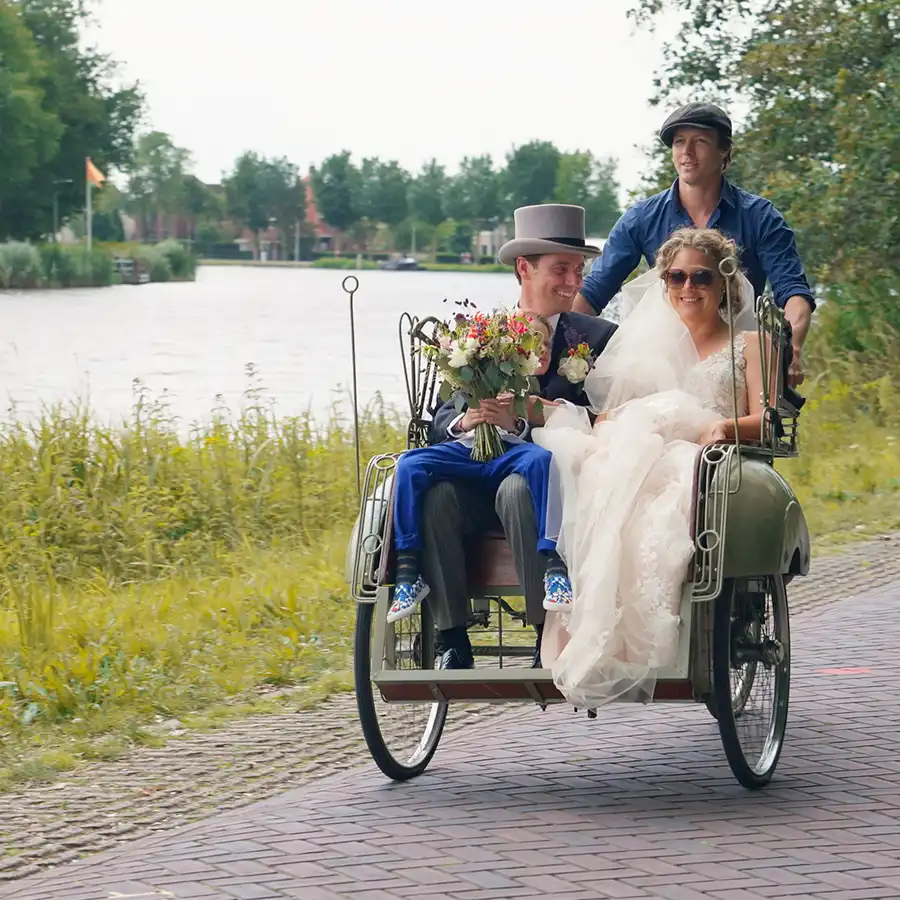 Bruidspaar in een bakfiets tijdens hun huwelijk.