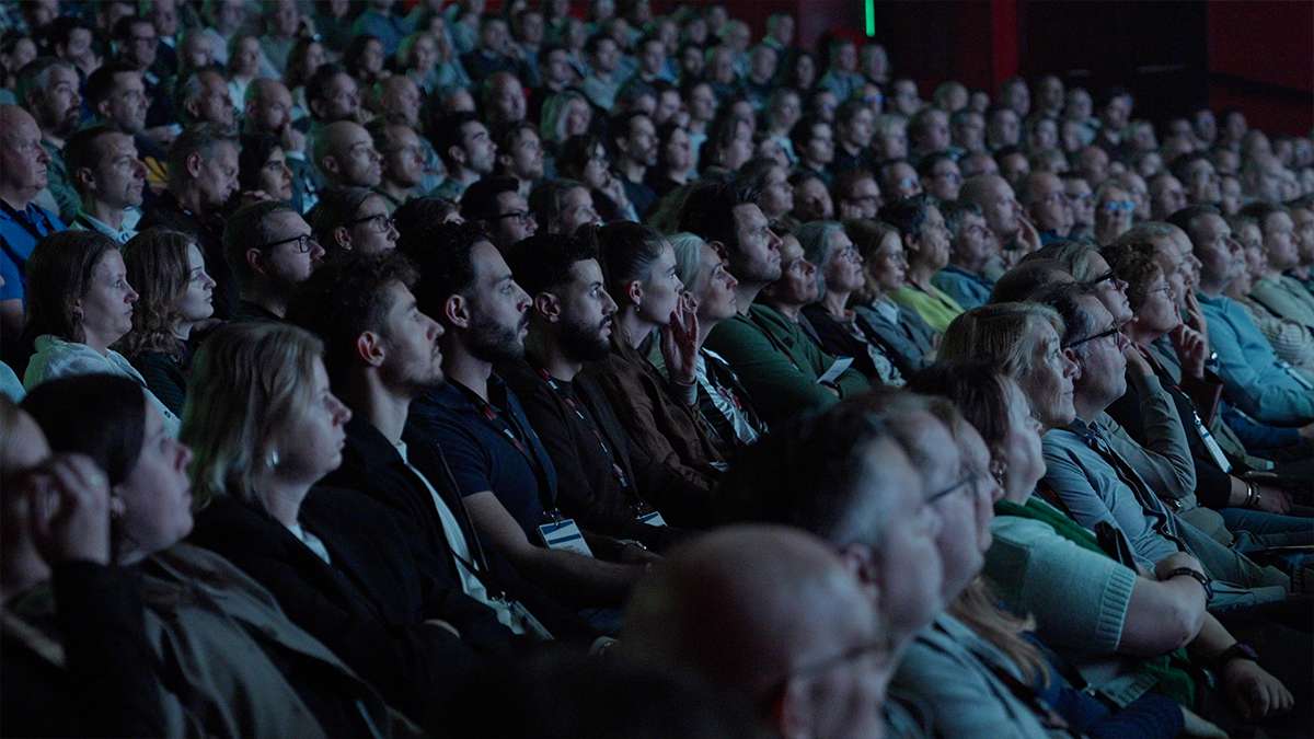 Shot van het publiek die kijkt naar een presentatie.
