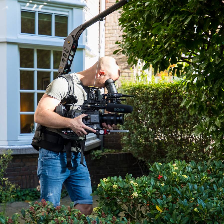 Videograaf maakt opnames met een professionele camera rig voor een bedrijfsvideo