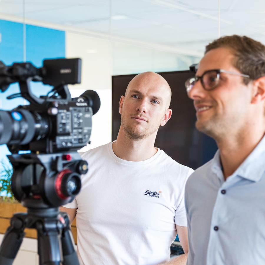 Videomaker filmt een interview voor een bedrijfsfilm tijdens een professionele videoproductie